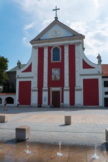 Church with striking red façade and adjoining fountain, Church of St Peter and Paul, Litewski
