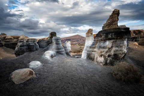 Eroded rock formations, volcanic landscape with dramatic cloudy skies, Ciudad Estratificada or Los