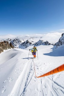Ski tourer with rope, rope team on the Vadret da Porchabella glacier on the ascent to the summit of