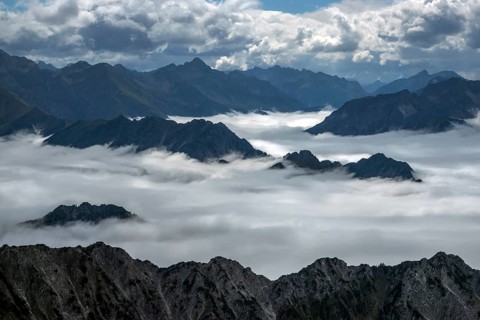 View from the Nebelhorn summit to mountains of the Allgäu Alps, mountains rising from fog in the