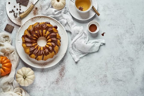 From above autumn breakfast composition with homemade round cruller with chocolate topping cup of