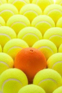 Macro Set of Brand New Tennis Balls and One Orange