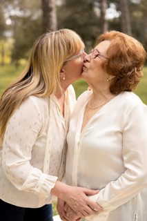 A heartwarming scene capturing a mother and daughter sharing a tender kiss in a serene outdoor