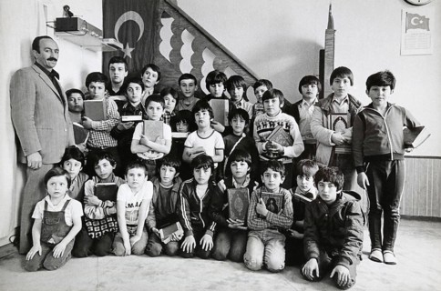 Children from a Koran school stand together with Hodscha Mehmet Özdemir for a group portrait,
