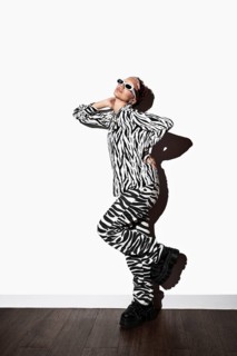 A model poses confidently in a striking zebra animal print ensemble. Wearing stylish sunglasses,