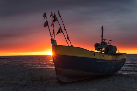 Fishing boat on the beach at sunset. Baltic sea