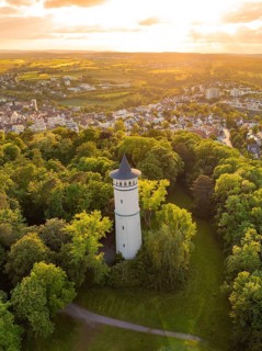 Tower surrounded by dense forest at sunset with a view of a village, Engelberg Tower, Leonberg,