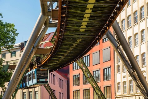 A suspension railway runs between old industrial buildings near the Kluse stop, Wuppertal, Germany