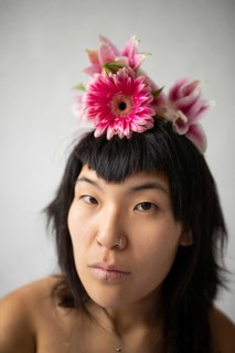 Captivating portrait of an Asian woman wearing a floral headpiece, showcasing her unique style with