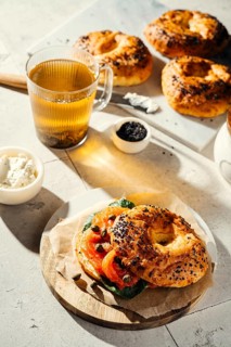 Delicious freshly baked bagels topped with tomatoes, capers, and greens. Served with a glass of hot