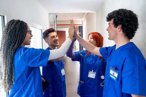 Medical students or young healthcare professionals celebrating success and demonstrating team