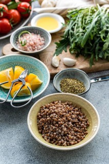 A vibrant display of healthy lunch ingredients includes fresh rocket, oregano, cherry tomatoes,