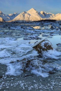 Morning light over snow-covered mountains, fjord, low tide, winter, Lyngen Alps, Norway
