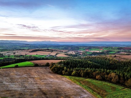 Sunset of Devon Farms and Fields over Berry Pomeroy from a drone, Totnes, England, United Kingdom