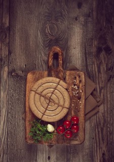 Raw spiral sausages, on a wooden board, top view, no people