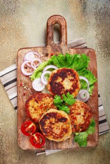 Fried chicken cutlets, minced chicken, with vegetables, on a cutting board, with vegetable salad,