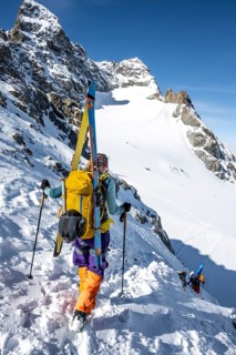 Mountaineer with skis at the fork Porta d'Es-cha, view of mountain peak Piz Kesch and glacier