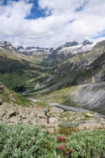 Mountaineer on a hiking trail in front of a picturesque mountain landscape, rocky mountain peaks