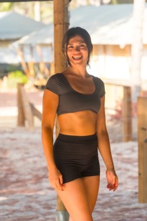 Yoga instructor smiling and starting a meditation session in a glamping resort, wearing black