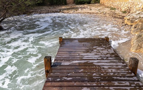 Wooden walkway destroyed by the sea, east coast in Cala Ratjada, Majorca, Spain