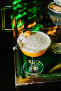 A beautifully crafted peach cocktail viewed from above, showcasing its frothy texture and delicate
