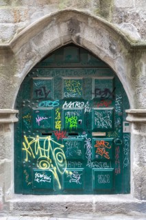Graffiti tags spray painted on historic door, city of Porto, Portugal