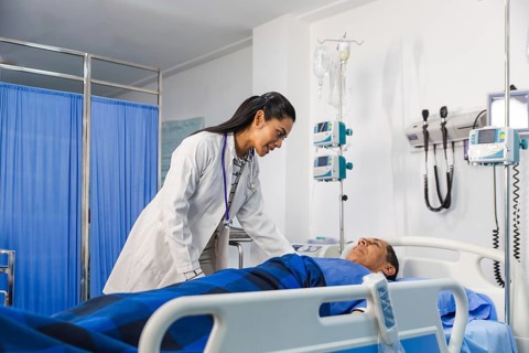 A compassionate female doctor attentively examines an elder patient in a hospital room,