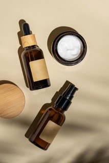 Top view of a sophisticated arrangement of cosmetic bottles with wooden caps and blank labels