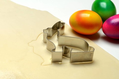 Rolled dough with bunny cookie cutter and easter eggs