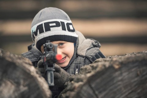 Five years old boy playing with a rifle toy