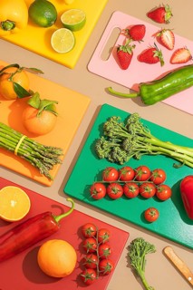A vibrant top down view of fresh fruits and vegetables on colorful cutting boards. The display