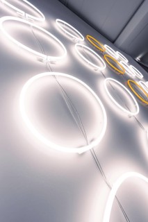 Neon lights in the shape of a circle on the wall create a modern, minimalist ambience, Schauwerk