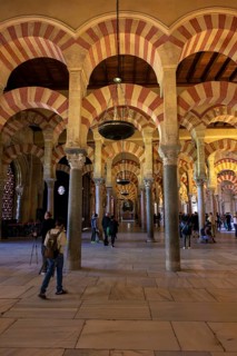 A long corridor with large arches and columns of the Cathedral Mosque of Córdoba