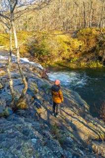 Female hiker admiring the zaldibartxo waterfall in the gorbeia natural park, basque country, spain,