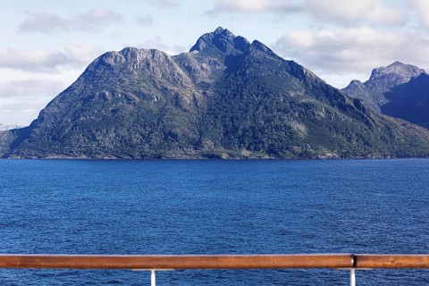 View of a distinctive, steeply rising mountain in the center of the picture taken from the deck of