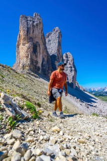 Tourist walking on the scenic trail leading to the tre cime di lavaredo, enjoying the breathtaking