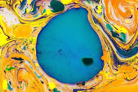 A dynamic abstract artwork featuring vibrant swirling colors of yellow, blue, green, and orange,