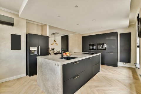 A stylish modern kitchen featuring sleek cabinetry, sophisticated appliances, and elegant lighting