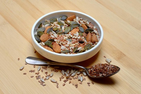 Seeds in bowls, mix of almond seeds, sunflower seeds, linseeds and pumpkin seeds