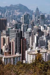 A stunning view of the densely packed Hong Kong skyline, captured from a hilltop. The image
