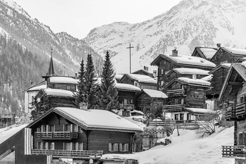 Snow-covered old farmhouses, large wooden cross, black and white photo, historic town center,