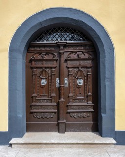 Two-wing, old wooden door, arched door with artfully carved ornaments in the old town of