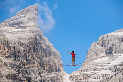 Slackliner in the mountains, mountain peaks of the Brenta Mountains, at Refugio Francis Fox