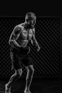 The dramatic black white image of the MMA fighter. Photography in a real octagon. Brutal fighter.