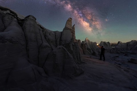 A breathtaking view of Goblin Valley's sandstone structures under a captivating night sky. A lone