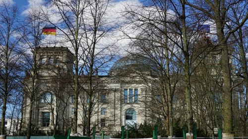 The Reichstag building with German flag and wintery trees in the foreground, Berlin
