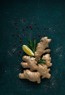 Ginger root, on a dark background, with rosemary, lemon and pepper, concept, food background, no