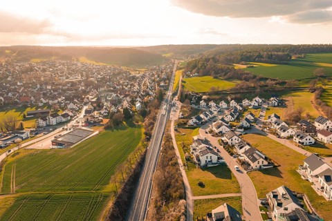 View of a village with railroad tracks and agricultural land at sunset, Hermann Hesse Railway,
