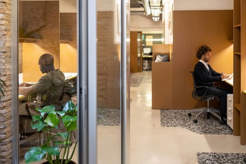 Bright and modern coworking space in Barcelona with professionals working at their desks. The