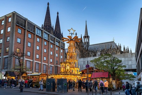 Christmas pyramid at Christmas market Adventsdorf am Kölner Dom at dusk, Cologne, North
